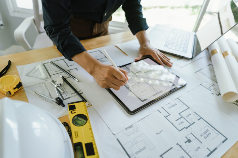 Architect engineer design work on initial project drawings, construction plans, architectural design, drafting blueprints and construction modeling.